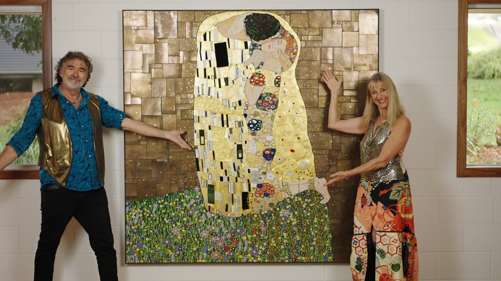 Brett Campbell and Kari standing with The Kissing Project mosaic